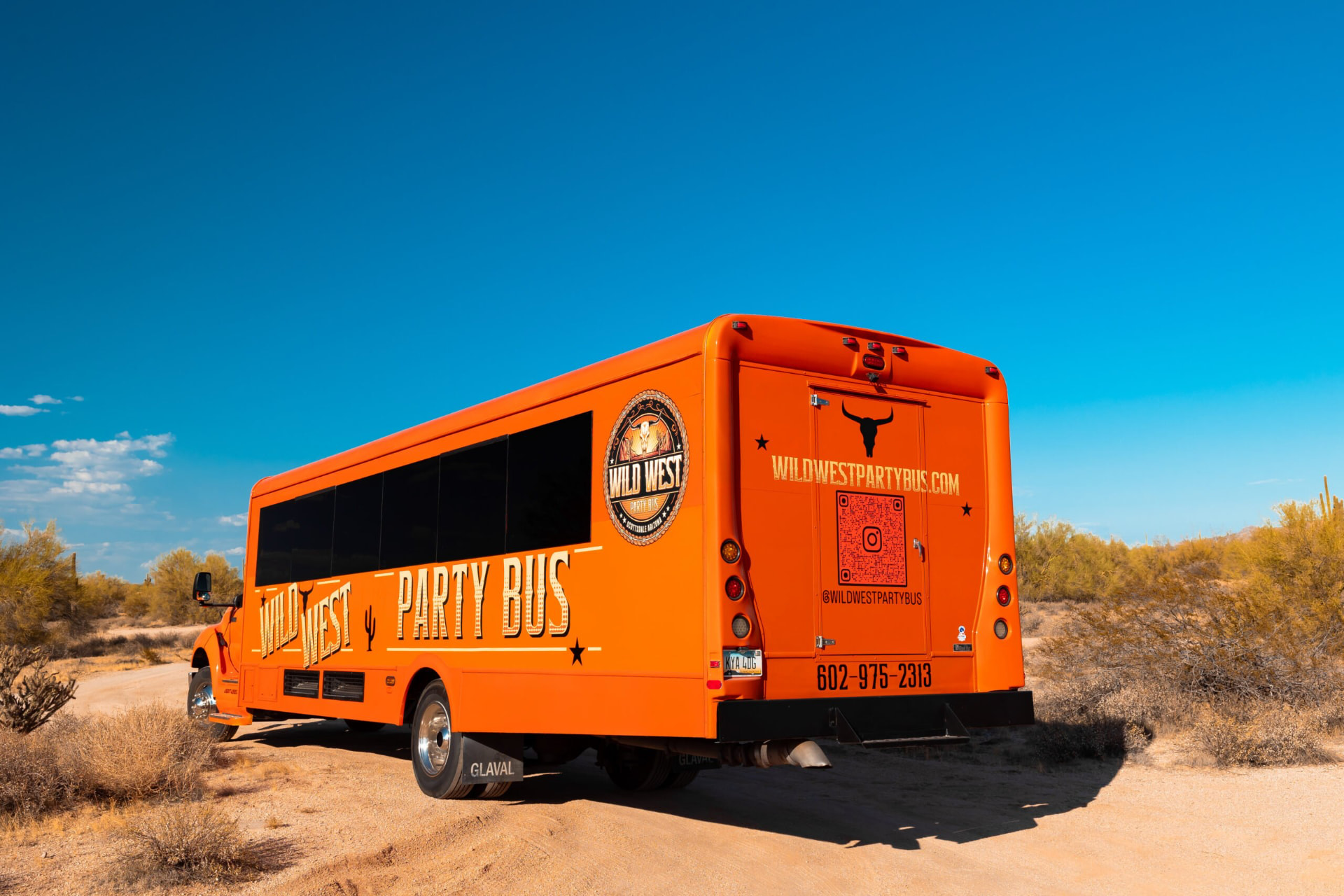 Rear view of the Wild West Party Bus on a desert road heading out to Cave Creek
