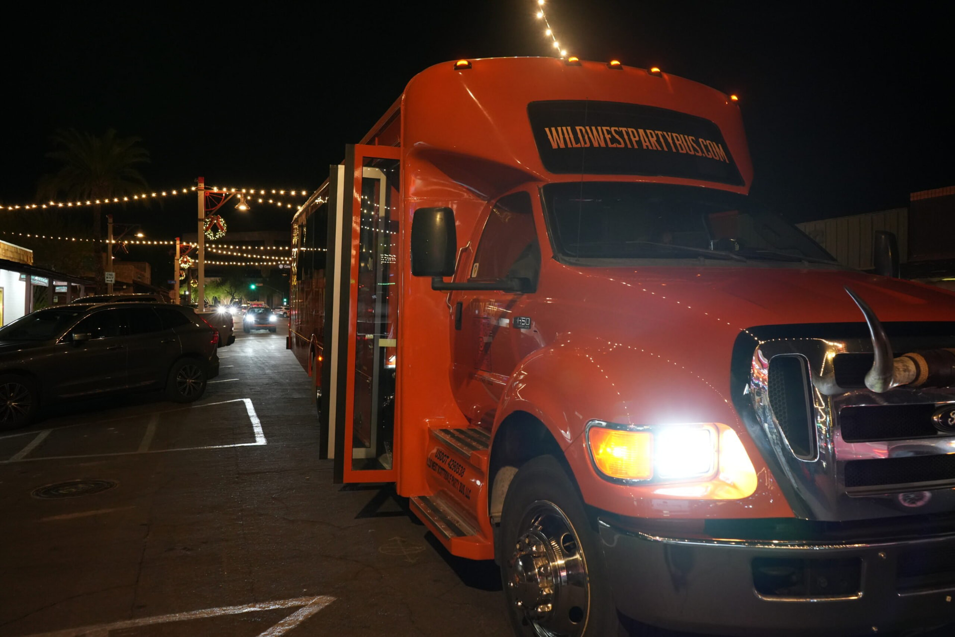 The party bus stopped under string lights in Old Town Scottsdale at night